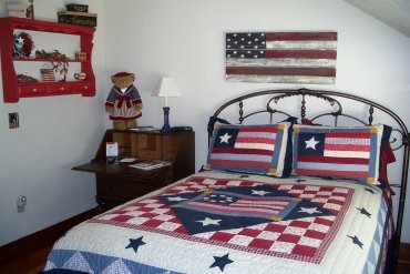 Another upstairs room, the Americana room with full sized bed has a desk with chair and small armoire.