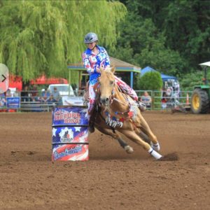 Woman riding a horse around a barrel