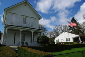 Big white house with a flag on a pole out front